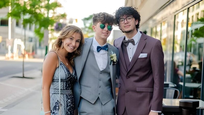 Drei Schüler der Mountainview High School stehen zusammen auf einer Straße in der Stadt mit Grünflächen und Gebäuden im Hintergrund.