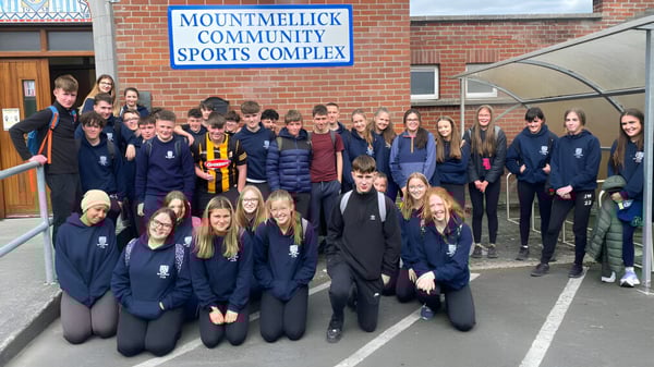 Eine Gruppe Schülerinnen und Schüler steht vor dem Gebäude des Mountmellick Community School Sports Complex.