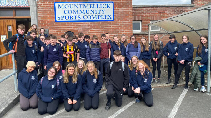 Eine Gruppe Schüler steht vor der Sportanlage der Mountmellick Community School.