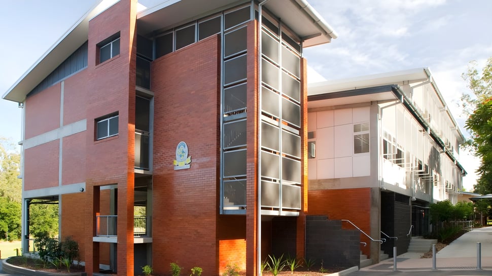 Das moderne mehrstöckige Gebäude der Moyne Community School mit großen Fenstern und einem begrünten Eingangsbereich.