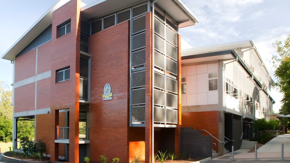 Das moderne mehrstöckige Gebäude der Moyne Community School mit großen Fenstern und einem begrünten Eingangsbereich.