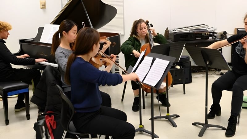 Eine Gruppe Schülerinnen und Schüler der Moyne Community School probt gemeinsam mit Musikinstrumenten in einem Raum.