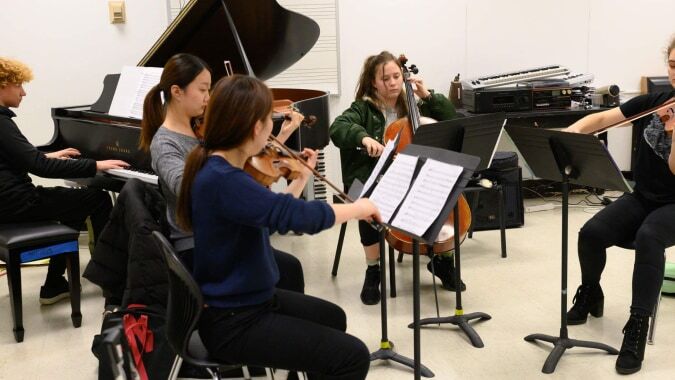 Schüler der Moyne Community School spielen gemeinsam verschiedene Musikinstrumente in einem Musikraum.