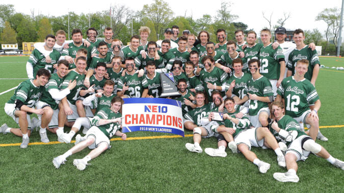 Die Sportmannschaft der Moyne Community School versammelt sich auf dem Spielfeld und hält ein Banner mit der Aufschrift NEIO CHAMPIONS.