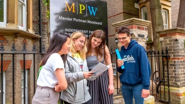 Eine Gruppe von Schülern steht vor dem Gebäude der MPW Birmingham und unterhält sich.