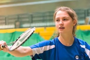 Eine Schülerin der MPW London spielt ein Tennismatch auf dem grünen Tennisplatz der Schule.