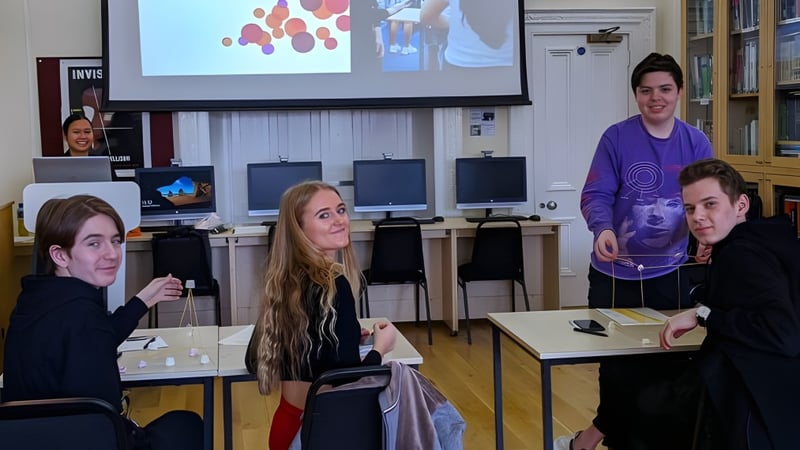 Eine Gruppe Schülerinnen und Schüler im Klassenraum der MPW London mit einem projizierten bunten Bild auf der Leinwand.