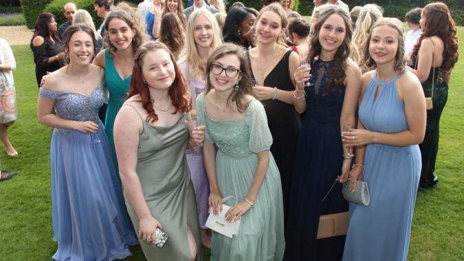 Eine Gruppe junger Schülerinnen in formellen Kleidern posiert zusammen im Freien auf dem Gelände des Mullingar Community College.