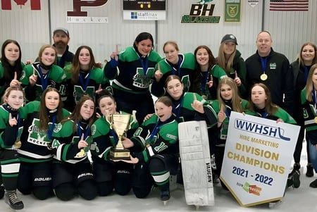 Schülerinnen des Murdoch Mackay Collegiate feiern zusammen mit einem Pokal ihren Sieg bei der Hockey-Meisterschaft.