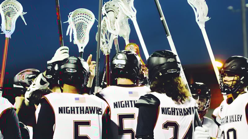 Eine Gruppe von Lacrosse-Spielern der Murietta Valley High School trägt weiße Trikots mit dem Schriftzug NIGHTHAWKS auf dem Rücken.