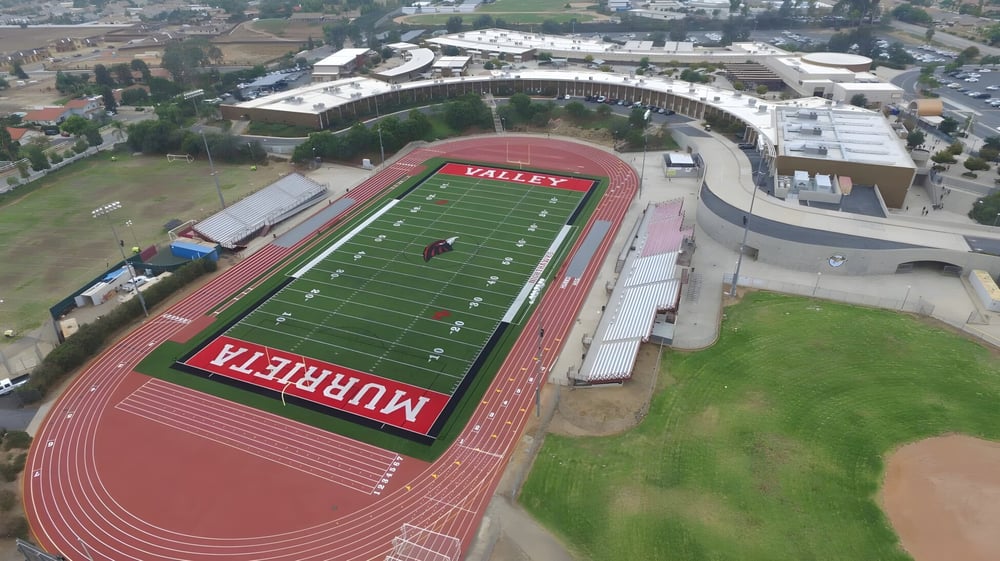 Luftaufnahme des großen Sportstadions mit rotem Fußballfeld und Laufbahn im Murrieta Valley Unified School District.
