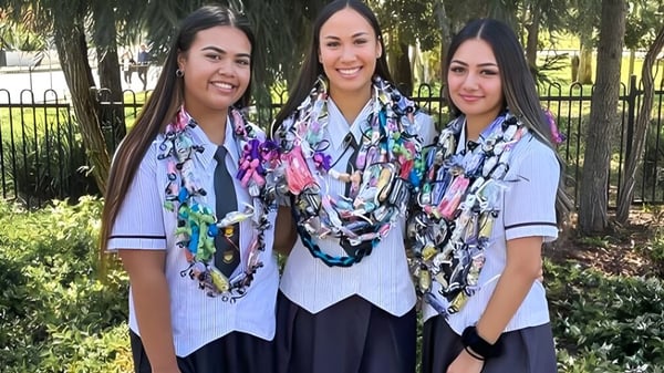 Drei Schülerinnen in Schuluniformen stehen zusammen in einer grünen Außenanlage auf dem Campus des Murrumba State Secondary College.