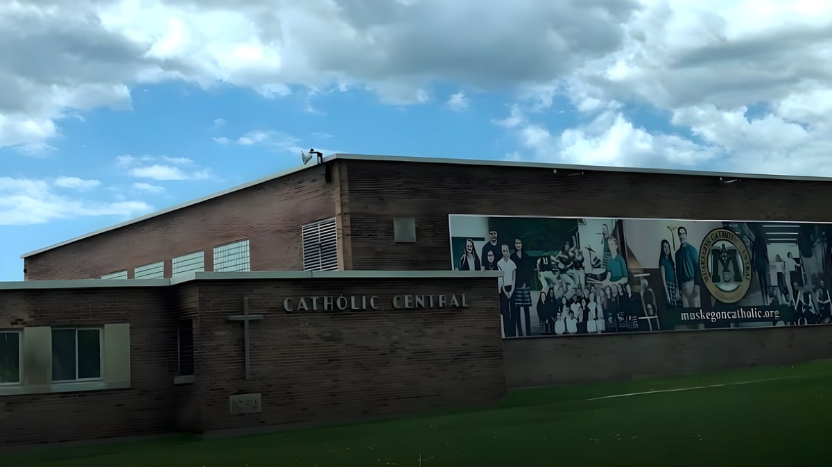 Das Backsteingebäude der Muskegon Catholic Central High School vor einem bewölkten blauen Himmel.