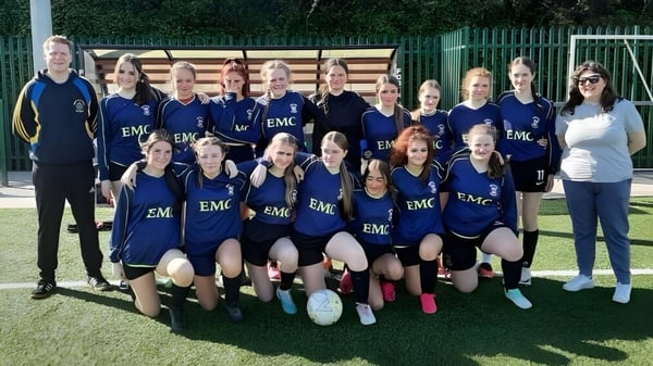 Eine Gruppe weiblicher Fußballspielerinnen posiert auf dem Sportplatz des Nagle Community College.