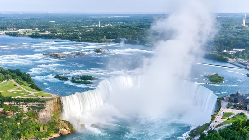 Ein Wasserfall fließt vor einer üppigen grünen Landschaft nahe der Nakusp Secondary School.