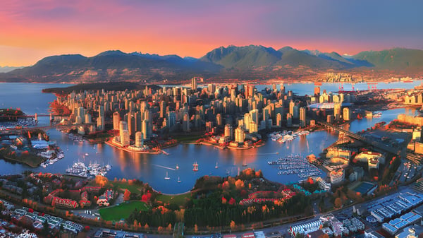 Luftaufnahme der Stadt mit Bergen und Hafen im Sonnenuntergang in der Nähe der Nanaimo District Secondary School.