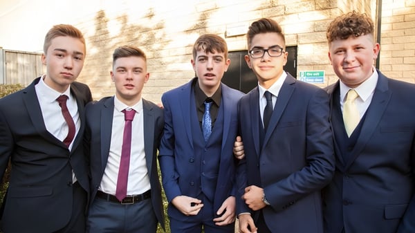 Eine Gruppe von fünf Schülern in formeller Kleidung steht vor einem Backsteingebäude auf dem Campus der Napier Boys High School.