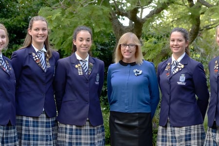 Eine Gruppe von Schülerinnen steht gemeinsam im grünen Außenbereich der Napier Girls' High School.