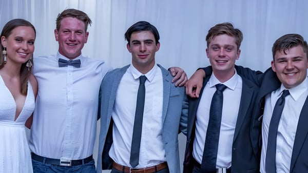 Fünf Personen posieren gemeinsam vor einem weißen Hintergrund auf dem Campus der Naracoorte High School.