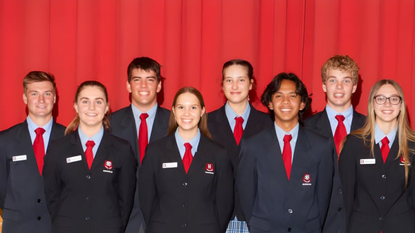 Eine Gruppe Schülerinnen und Schüler der Naracoorte High School steht vor einem roten Vorhang in Schuluniform.