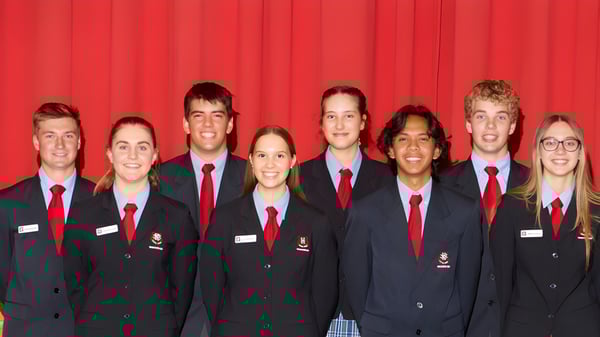 Eine Gruppe Schülerinnen und Schüler der Naracoorte High School steht vor einem roten Vorhang in Schuluniform.