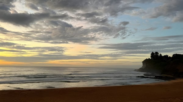 Dramatischer Sonnenuntergang über der felsigen Küste in der Nähe der Narrabeen Sports High School.