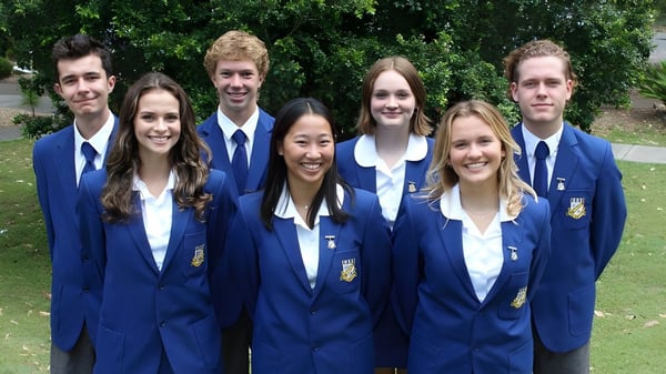 Eine Gruppe Schüler der Narrabeen Sports High School steht zusammen auf einer Wiese mit Bäumen im Hintergrund.