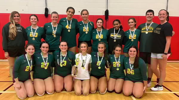 Eine Gruppe weiblicher Athletinnen der Nativity BVM High School posiert mit Medaillen in der Sporthalle.