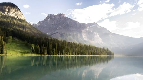 Ein alpiner See mit schneebedeckten Bergen und Waldlandschaft nahe der Nechako Valley Secondary School.