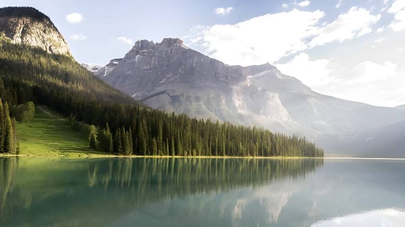 Ein alpiner See mit schneebedeckten Bergen und Waldlandschaft nahe der Nechako Valley Secondary School.
