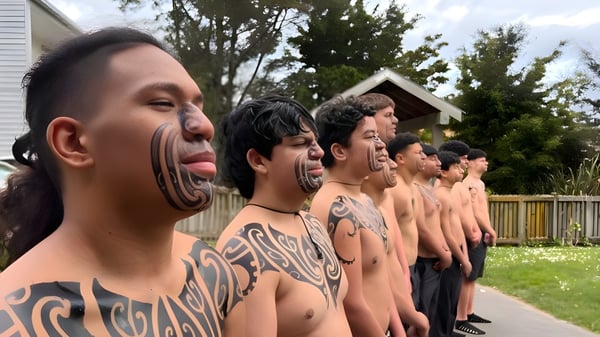 Eine Gruppe tätowierter Schüler steht auf einer Wiese vor einer Holzkonstruktion auf dem Gelände des Nelson College for Boys.