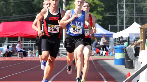Zwei Läuferinnen in Sportkleidung bei einem Wettkampf auf der Laufbahn der Nelson High School.