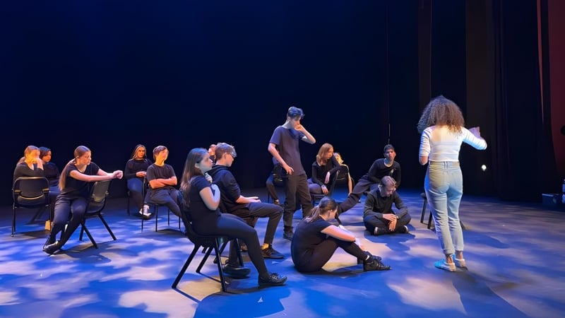 Schüler der Nepean High School versammeln sich auf einer Bühne mit blauer Beleuchtung.