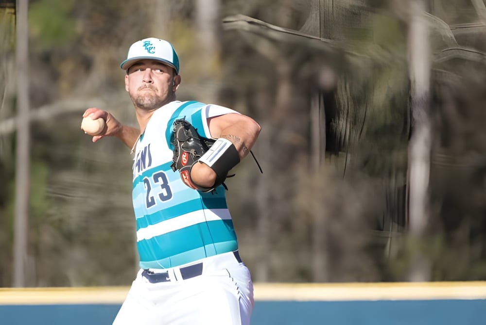Ein Baseballspieler in blauer und weißer Uniform steht auf dem Spielfeld auf dem Campus des New Brunswick Community College.