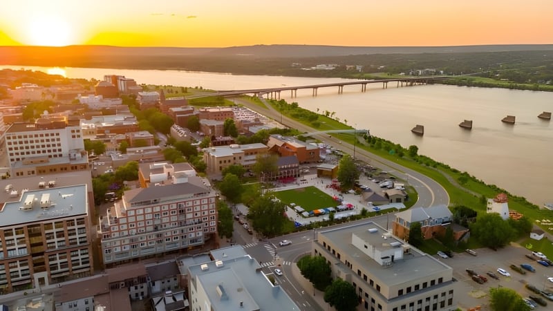 Der Stadtblick mit Fluss und grünen Ufern bei Sonnenuntergang zeigt die Umgebung des New Brunswick Community College.