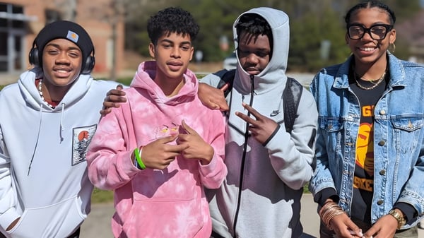 Vier Schülerinnen und Schüler stehen gemeinsam draußen auf dem Campus der New Garden Friends School.