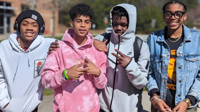 Vier Schülerinnen und Schüler stehen gemeinsam draußen auf dem Campus der New Garden Friends School.