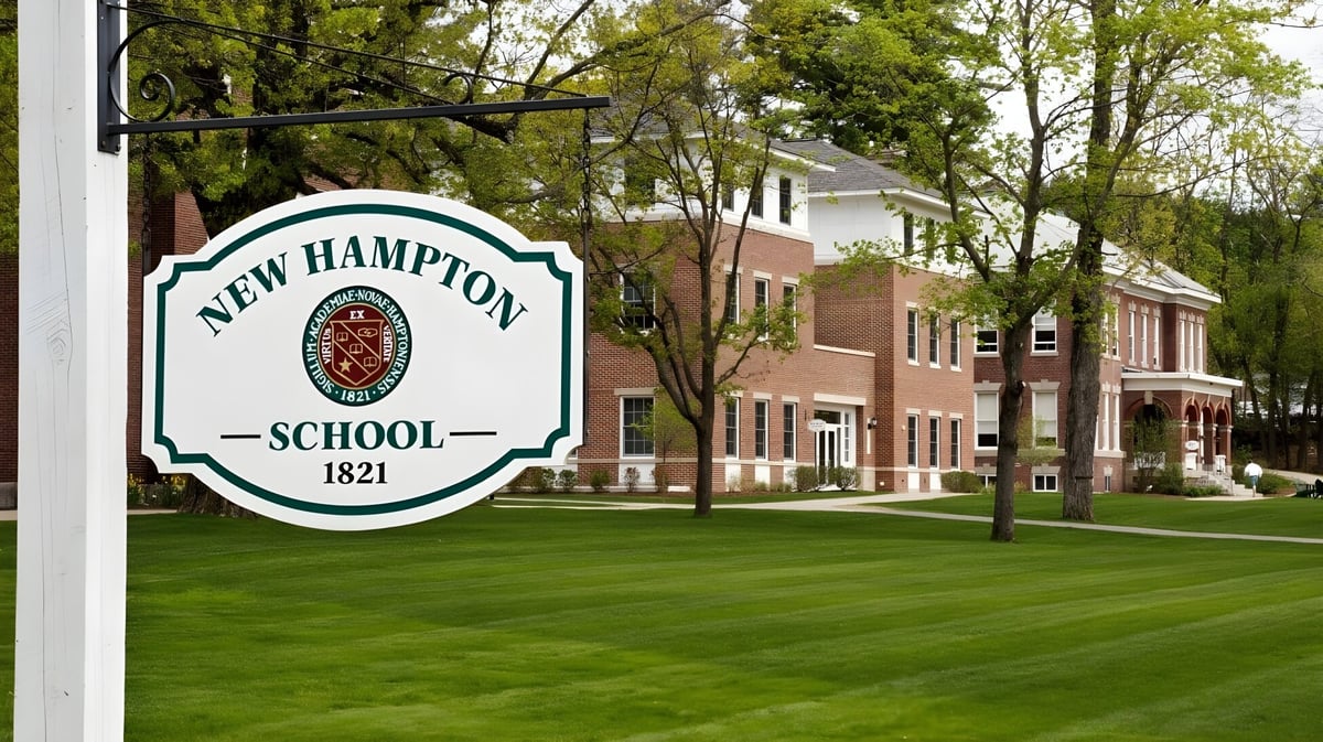 Das Backsteingebäude der New Hampton School ist umgeben von grünen Bäumen und einem gepflegten Rasen.