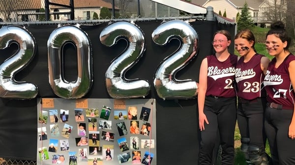 Drei Schülerinnen stehen vor großen aufblasbaren Zahlen mit dem Jahr 2022 an der N.E.W. Lutheran High School.