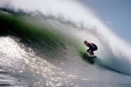 Ein Surfer reitet eine große Welle an der Küste in der Nähe der New Plymouth Boys' High School.