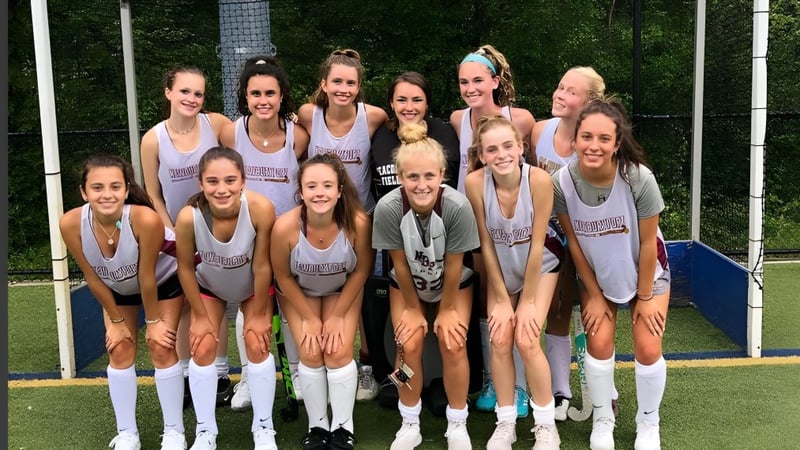 Eine Gruppe junger Athletinnen steht auf dem Sportplatz der Newburyport High School.