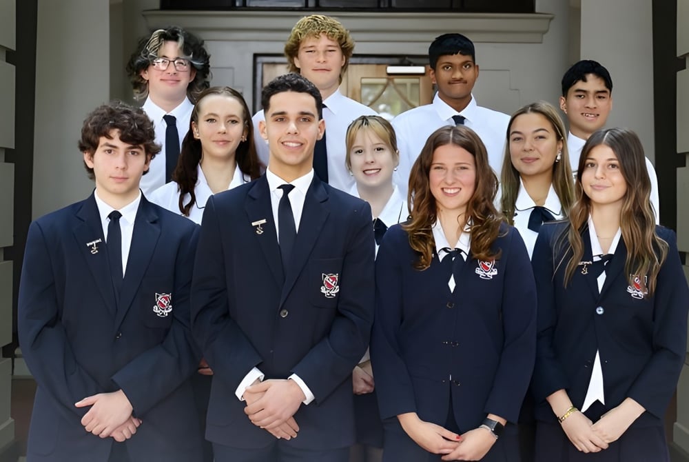 Eine Gruppe Schüler der Newcastle High School steht vor einem Gebäude mit traditioneller Architektur.
