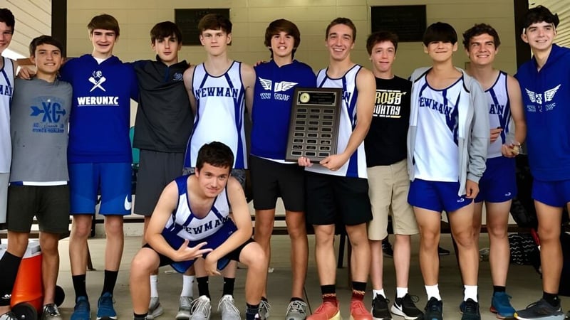 Die Basketballmannschaft der Newman Central Catholic High School posiert gemeinsam mit einer Siegertrophäe.