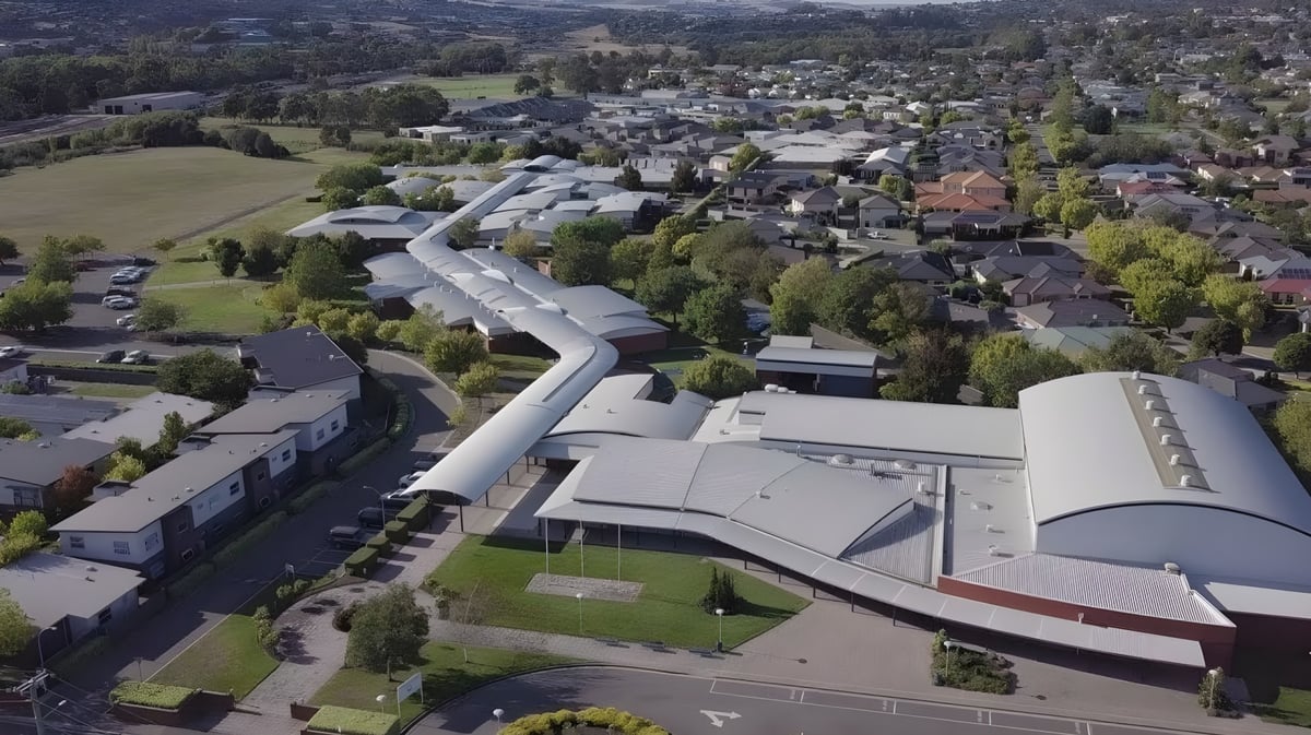 Das Newstead College ist als großer moderner Gebäudekomplex aus der Luftaufnahme in einer bewaldeten Landschaft zu sehen.