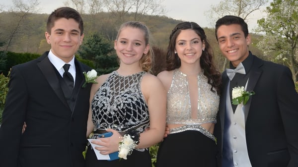 Vier Schüler der Newtown School stehen gemeinsam draußen vor einer grünen Waldkulisse.