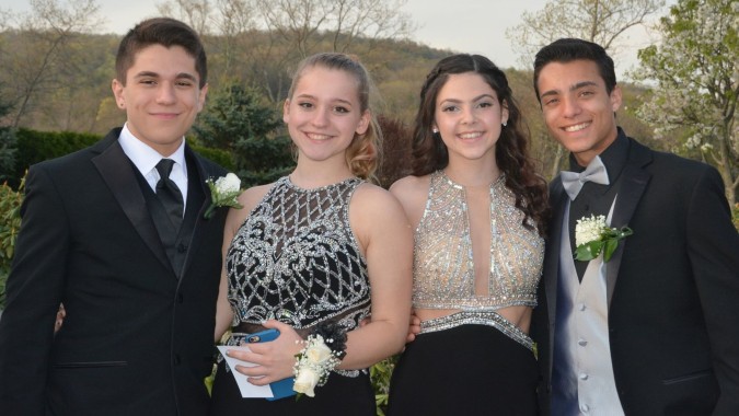 Vier Schüler der Newtown School stehen im Freien vor Bäumen und grüner Landschaft.