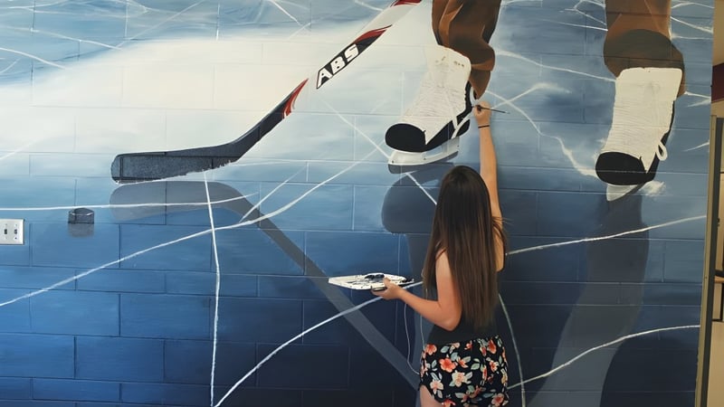 Das Wandbild an der NorKam Secondary School zeigt einen Hockeyspieler mit Schläger und Puck auf einer Eisbahn.