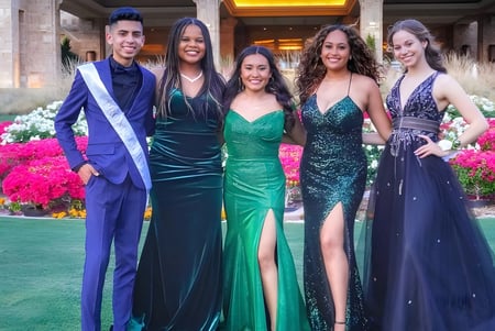 Fünf Personen in formeller Kleidung posieren gemeinsam in einem blumenreichen Außenbereich der North Canyon High School.