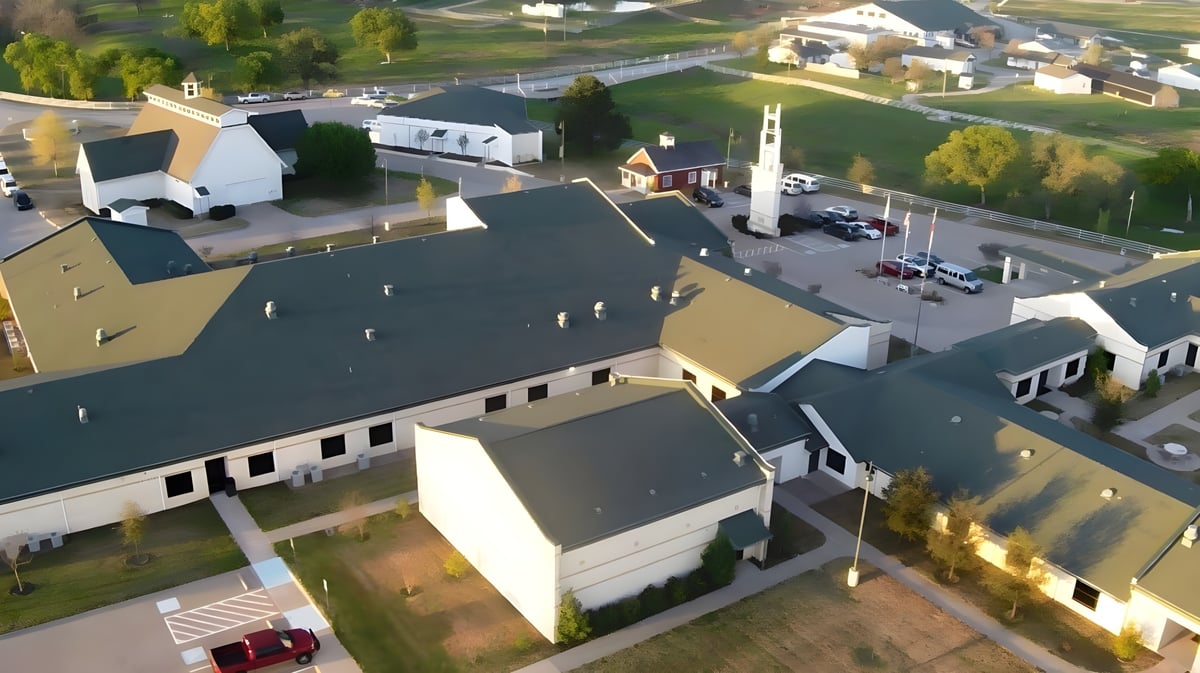 Blick auf das Hauptgebäude und die Umgebung der North Central Texas Academy mit Wohnhäusern und viel Grün.