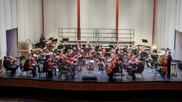 Ein großes Orchester der North Cross School spielt auf einer Bühne mit verschiedenen Instrumenten.